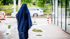 Symbolbild: Eine Frau im Niqab, auf dem Weg zu einem Auto. (Quelle: dpa/Robin Utrecht)