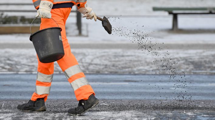 Symbolbild: Ein Arbeiter iat am 05.01.2017 in Schutzkleidung ist auf einem Gehweg in Potsdam mit Streuarbeiten beschäftigt. (Quelle: dpa-Zentralbild7Ralf Hirschberger)