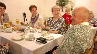 Mehrere Frauen und ein Mann sitzen an einer gedeckten Kaffeetafel und haben Spaß (Foto: rbb/Screenshot)